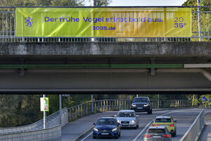 Werbung an Brücken und Banner an Seilen oberhalb von Straßen